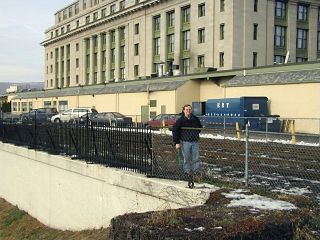 Aaron indicates the mark. The old station is in the background.