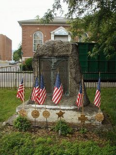 Eyelevel view of the benchmark set in the base of the flagpole.