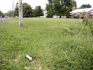 View looking west, showing brick house and utility pole BJ 10.