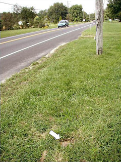 View looking west, showing utility pole, recessed mark and Route 26.