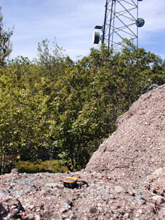 The mark sits on this large pink granite boulder. A communications tower stands in the background.