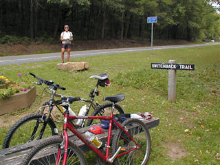 View facing north, showing ‘Switchback Trail’ sign and boulder; Rich at station mark.