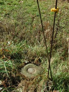 A pair of metal rods indicate the mark.