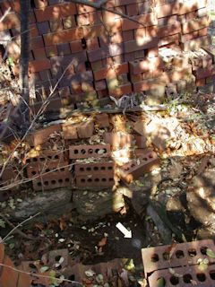 The bedrock is now surrounded by stone and piles of brick.