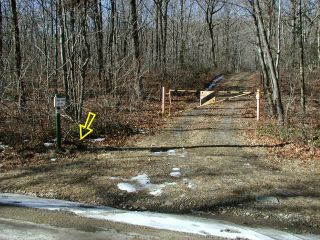 View west to sign and gate, mark indicated.