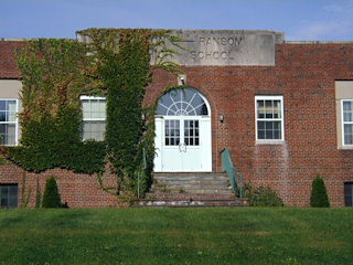 Though the letters are now half-covered with ivy, the name of the old school can still be discerned.