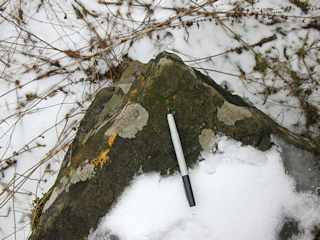 An eye-level view of the chiseled mark. The yellow paint can still be seen on the side of the stone.