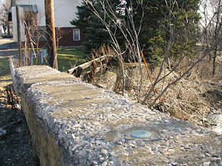 The mark is set on top of the crumbling east headwall, toward the south end. The mark itself is secure for now.