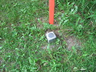 Eyelevel view of disk in small concrete monument.