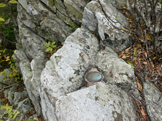 The station disk set snugly in the rock outcrop.