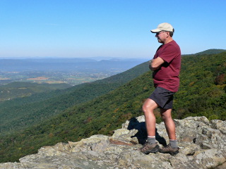 On a beautiful blue-sky day, Rich looks out over the landscape from Crescent Rock.