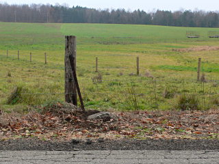 Looking S from the road toward the mark. It is obvious from this angle how the monument is tilted.