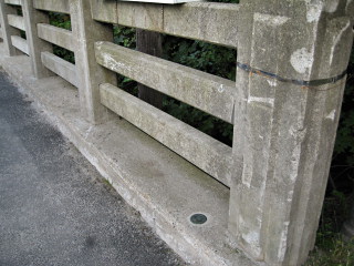 Eyelevel view of the benchmark disk in the bridge wall.