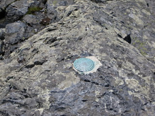 Eyelevel view of the station disk set in bedrock.