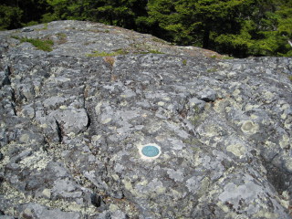 Eyelevel view of the reference mark disk set in bedrock.