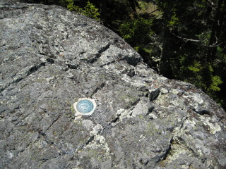 Eyelevel view of the reference mark disk set in bedrock. This one was quite precariously close to the edge!