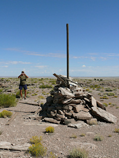 Station disk at base of cairn, and Rich taking a photo of the area.