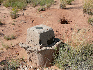 Eyelevel view of the monument, showing severe erosion of the surrounding soil.