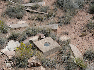 Eyelevel view of the station mark set in the concrete monument. It was surrounded by stone and wood debris.