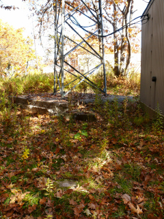 The triangulation station disk is adjacent to a small building and tower.