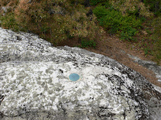 Eyelevel view of the reference mark disk set into bedrock.