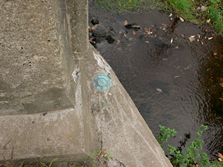 Eyelevel view of the disk set into the wingwall of the bridge.