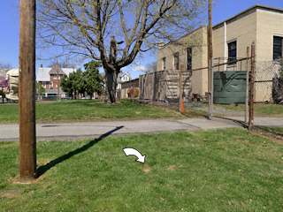 Proximity of the mark, light pole, and fenced-in area.