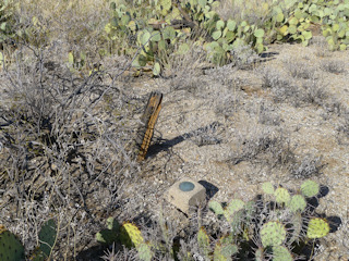 Eyelevel view of the azimuth mark disk set into concrete post, with the possible remnants of the witness post nearby.