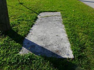 Eyelevel view of the disk set in the corner of the concrete pad.