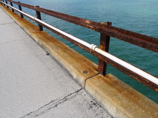 Eyelevel view of the bench mark disk on the concrete curb of the old bridge.