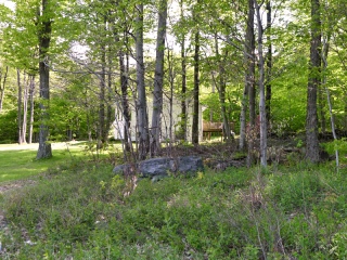 The house nearest to the wooded lot, as seen from near the mark.