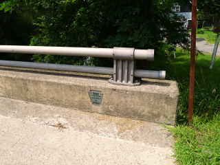 The disk is just behind this PDH 1963 bridge plaque.