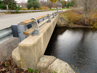 Eyelevel view of the disk on wingwall; looking NE along Graveyard Hill Rd.