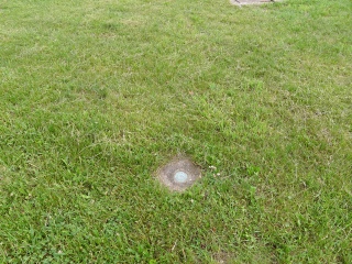 Eyelevel view of the disk on the square concrete monument.