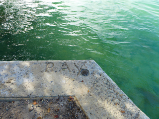 Eyelevel view of the bench mark disk on the corner of the seawall