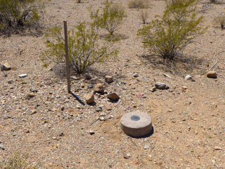 Eyelevel view of the disk in the round concrete monument, and the witness post