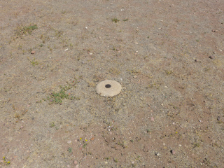 Eyelevel view of the disk on the round concrete monument