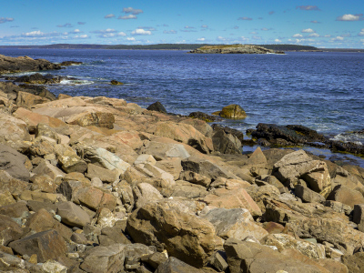 A rocky beach, beautiful water and a view of the Thrumcap