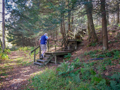 Dad begins to climb up the trail on the other side of the bridge.