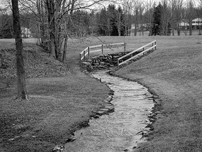 A real-photo postcard-like view of the creek