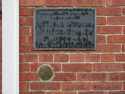 Eyelevel view of the disk set vertically on the brick wall of the building