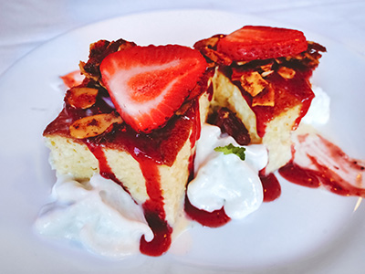 Quatro Leches cake with coconut espuma and strawberry blood orange coulis, topped with a spicy almond brittle