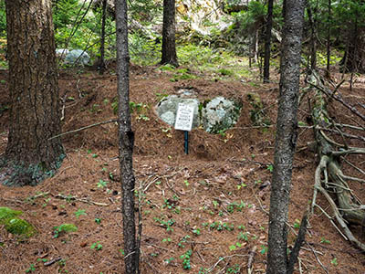 The mark is on the outcrop directly behind the sign.