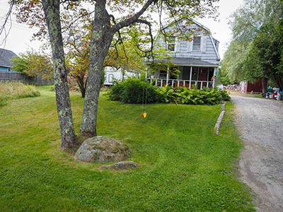 Proximity of boulder to house, driveway, and tree