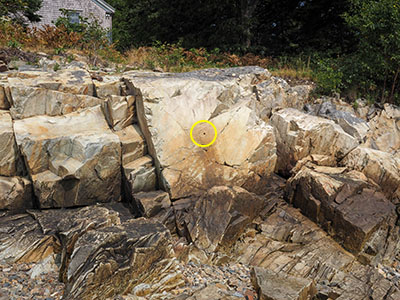 Eyelevel view of the drill hole, surrounded by carved triangle, on rock face