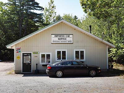 The auto shop; a trail to the boulder is just to the right (NW) of this building